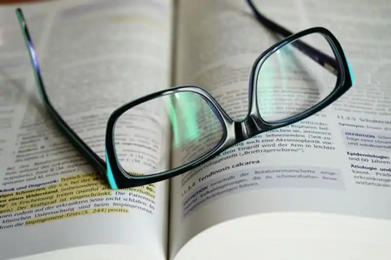 Kacamata Dengan Bingkai Hitam Di Buku