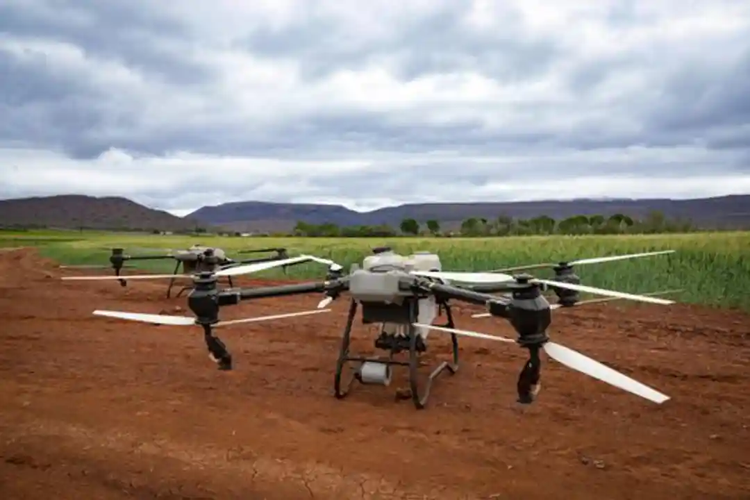 Drone pertanian di lahan, menampilkan teknologi pertanian modern dan lanskap.
