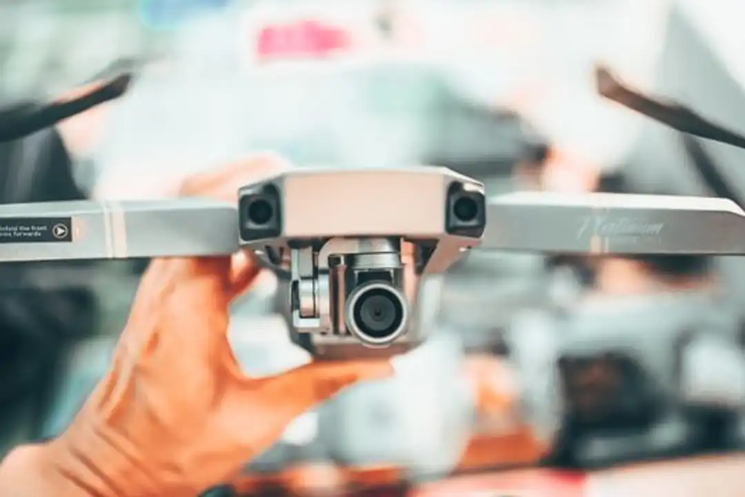 Fotografer pria menggunakan drone profesional dengan kamera di kota besar untuk pelatihan laporan survei drone.
